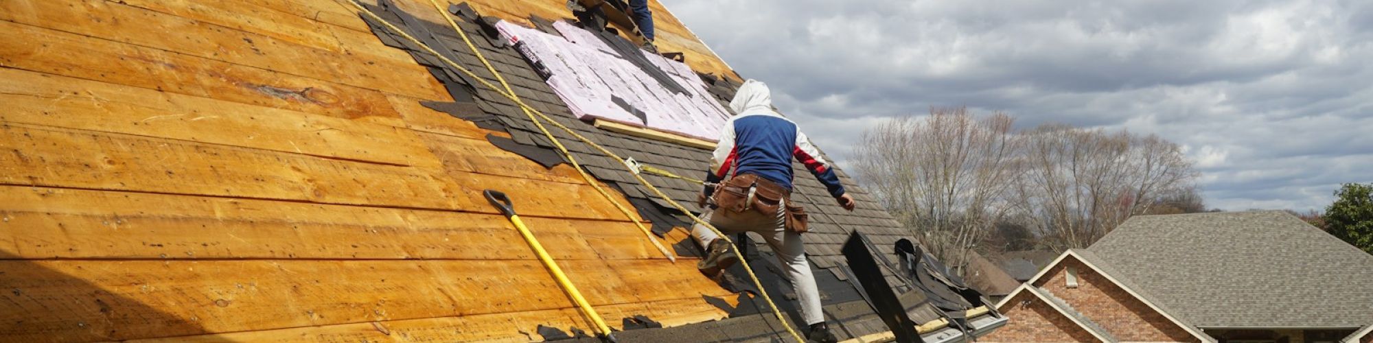 a couple of men working on a roof